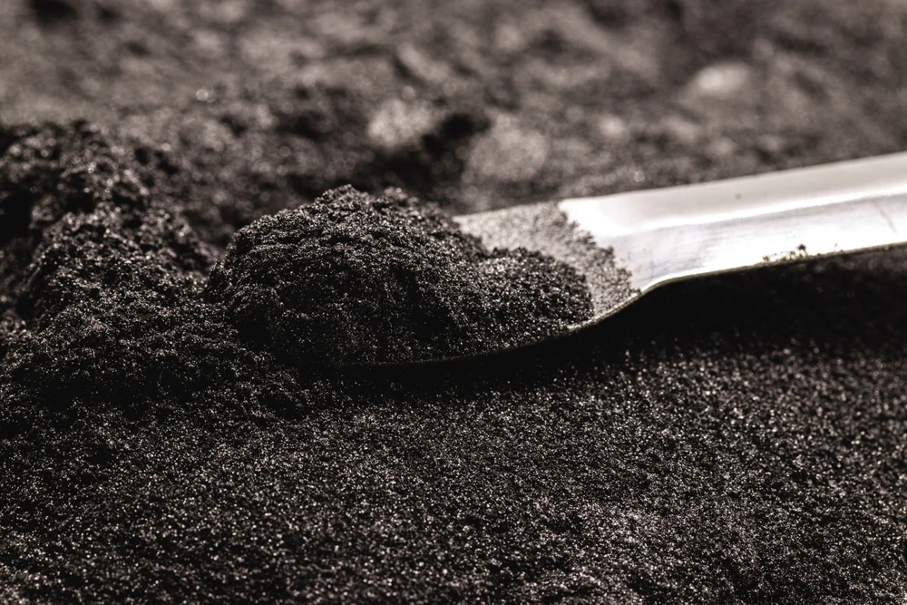 Polvere metallica fine raccolta con una spatola